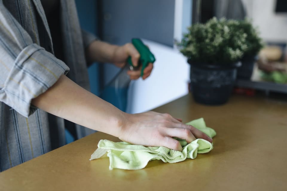 Een tafel wordt schoongemaakt met een doek